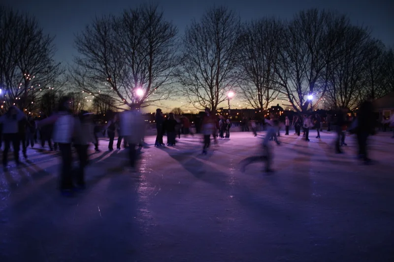 Skaters on the Hampton Court Palace ice rink at dusk